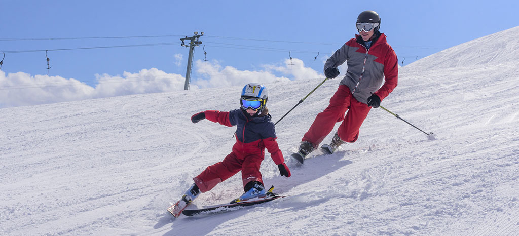 Kind mit Vater beim Skifahren